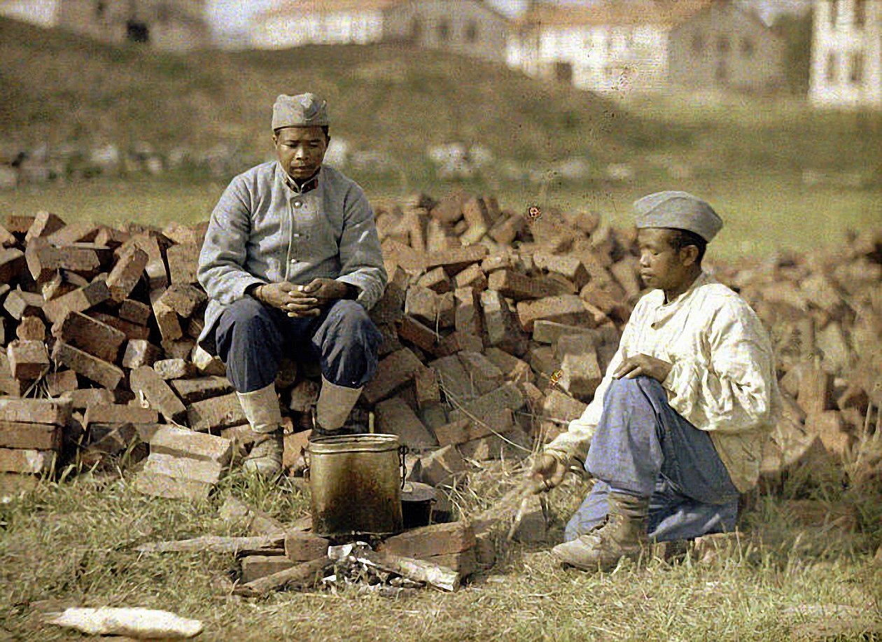 दो अफ्रीकी सैनिक एक भोजन गर्म कर रहे हैं, Soissons, Aisne, फ्रांस, 1917 (ऑटोक्रोम) द्वारा फर्नांड क्विल