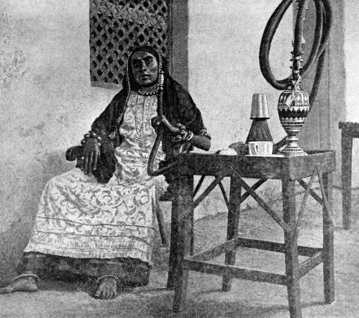 सोमाली महिला एक हुक्का धूम्रपान कर रही है, अदन, 1922 द्वारा अज्ञात